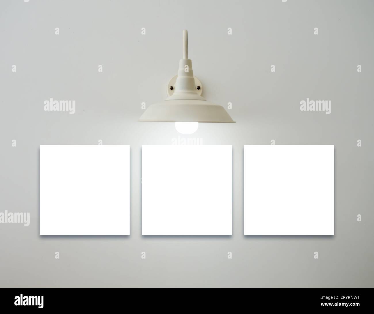 Mockup drei quadratische weiße leere Bilderrahmen hängen unter der Vintage Glühlampe auf weißem Hintergrund, minimalistischer Stil. Vorlagenbereich für Stockfoto
