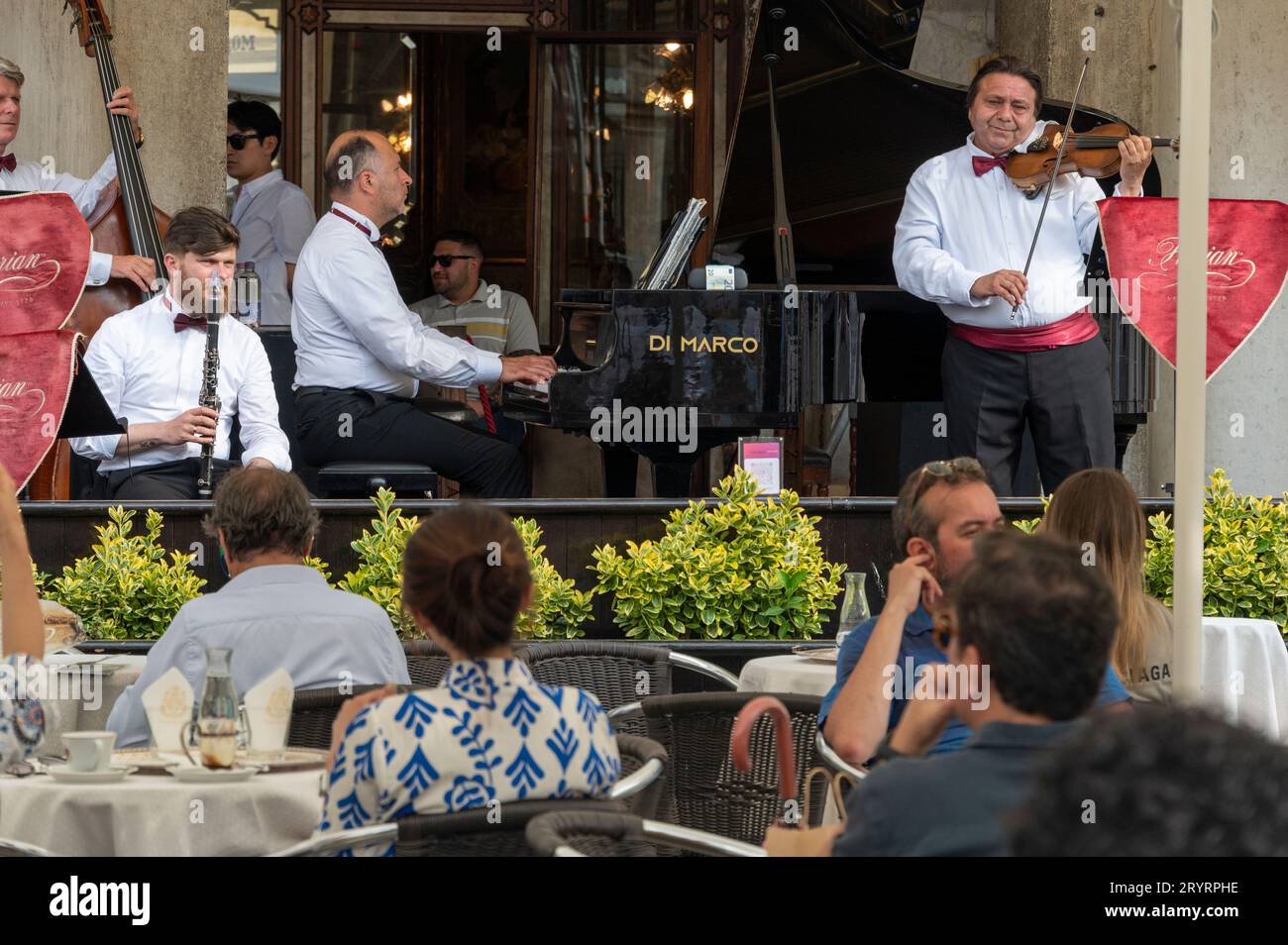 Eine Live-Band tritt bei Kunden auf, die im Caf Florian auf dem Markusplatz in Venedig in der venezianischen Region Norditalien sitzen. Stockfoto