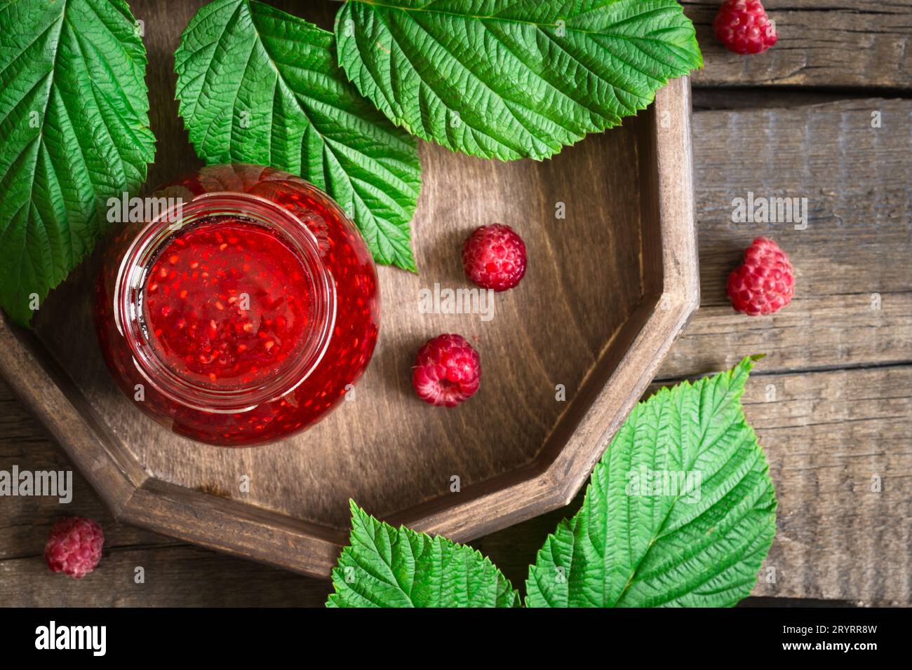 Hausgemachte Himbeermarmelade in einem Glas und frische Beeren Stockfoto