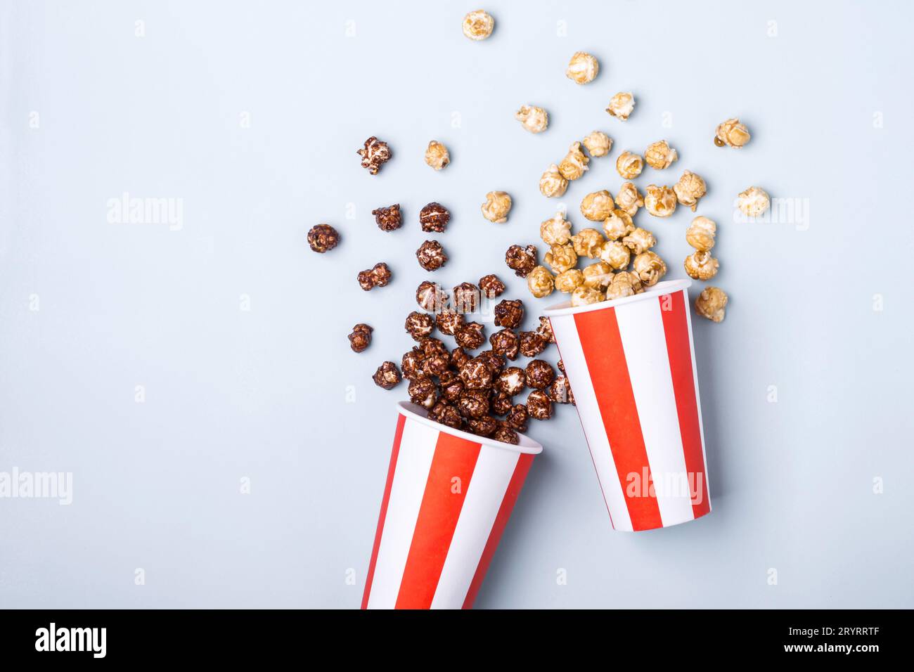 Süßes Karamell-Schokoladen-Popcorn in papiergestreifter weißer roter Tasse Stockfoto