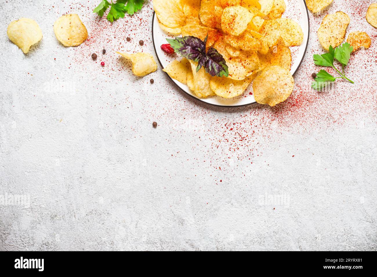 Gericht mit Kartoffelchips auf grauem Hintergrund Stockfoto