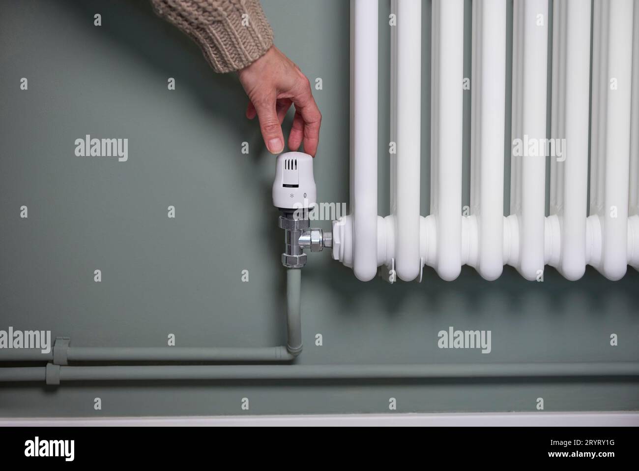 Nahaufnahme Des Handdrehens Des Thermostats Am Kühler Zu Hause, Um Energie Und Geld Zu Sparen Stockfoto