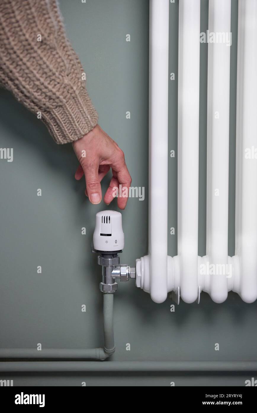 Nahaufnahme Des Handdrehens Des Thermostats Am Kühler Zu Hause, Um Energie Und Geld Zu Sparen Stockfoto