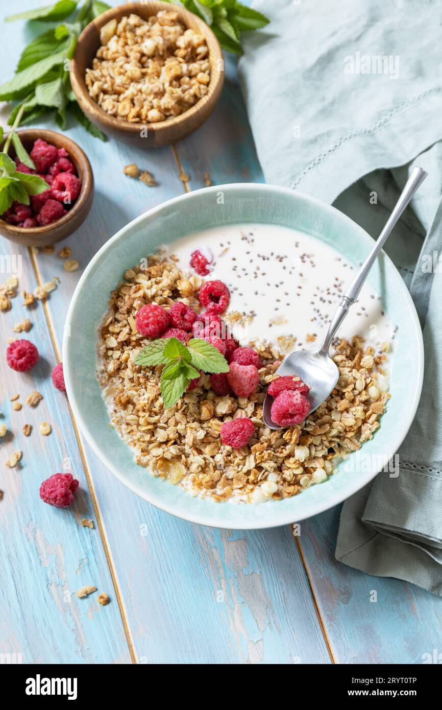 Ernährungskonzept. Gesundes Frühstückszerealien Schüssel hausgemachtes Müsli mit frischen Himbeeren und Chiasamen auf einem rustikalen Tisch. Co Stockfoto