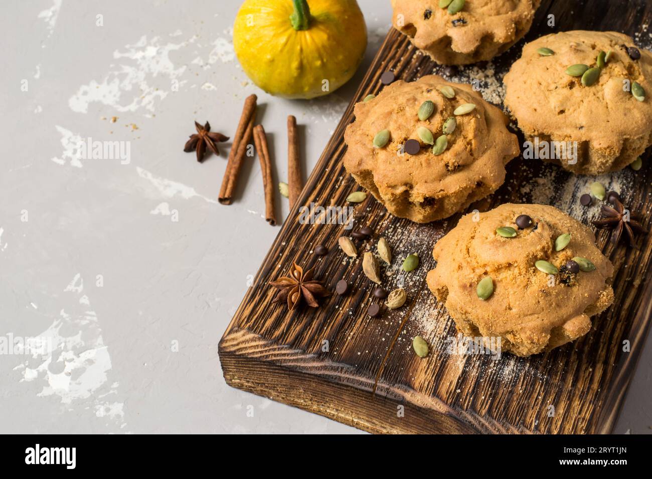 Kürbismuffins im Herbst mit Gewürzen, Schokoladentropfen und Kürbis Stockfoto