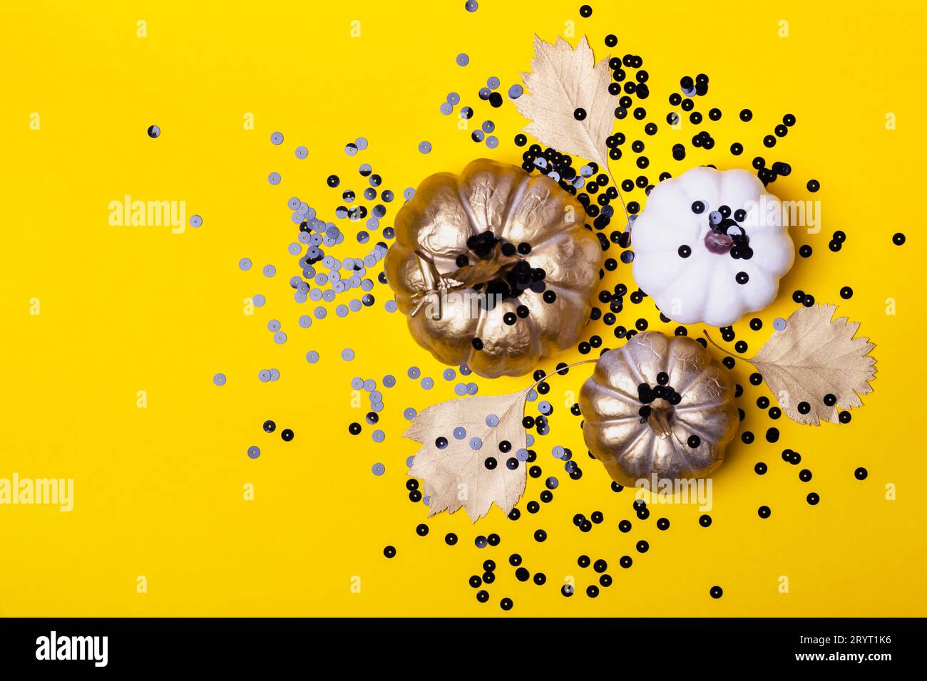 Halloween-Komposition aus dekorativen Kürbissen und schwarzen Glanzfunkeln Stockfoto