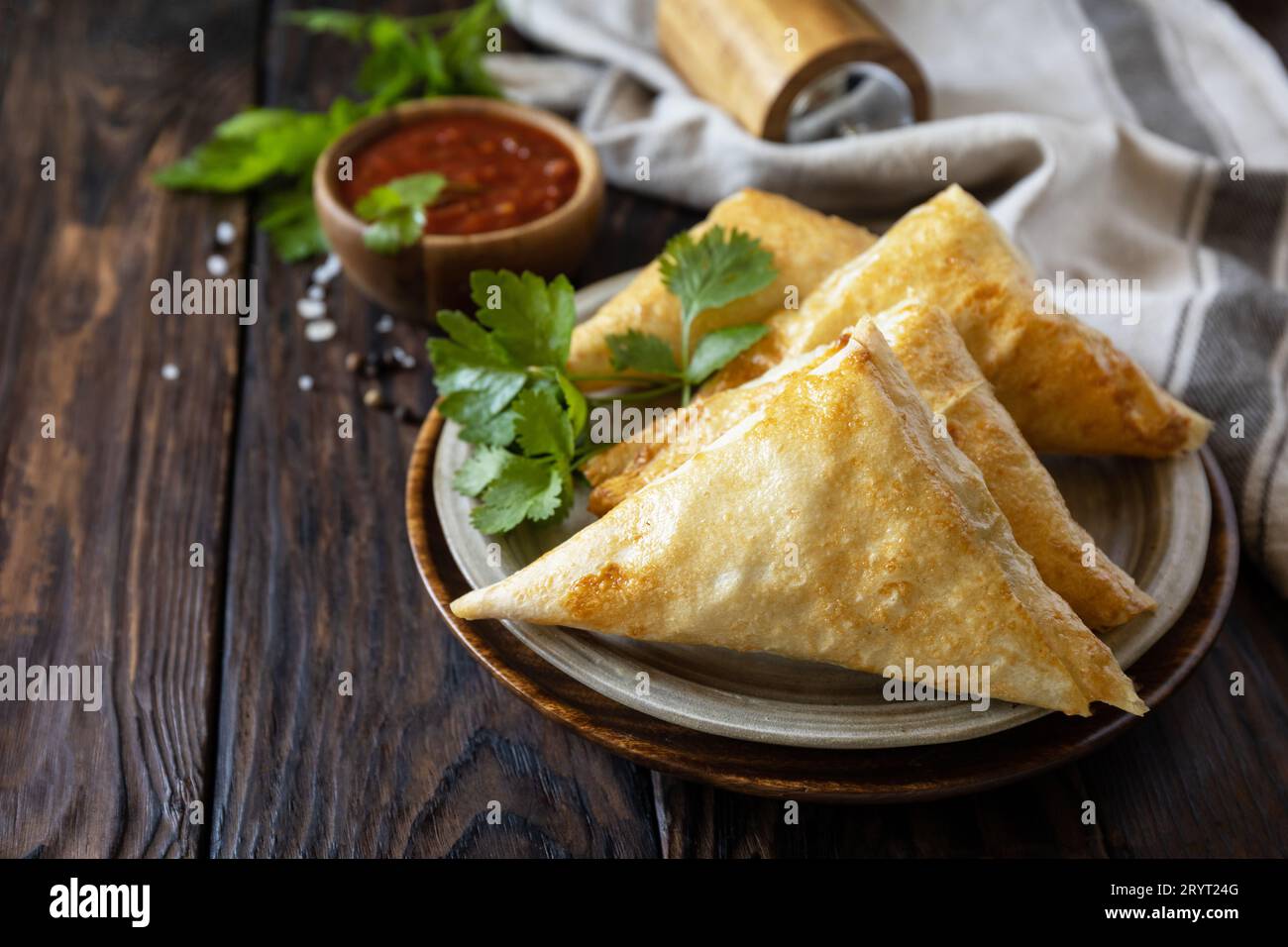 Asiatisches Essen. Vegetarische samsa (Samosas) mit Tomatensoße auf einem Holztisch. Beliebt in Indonesien als Risoles Sayur. Speicherplatz kopieren. Stockfoto