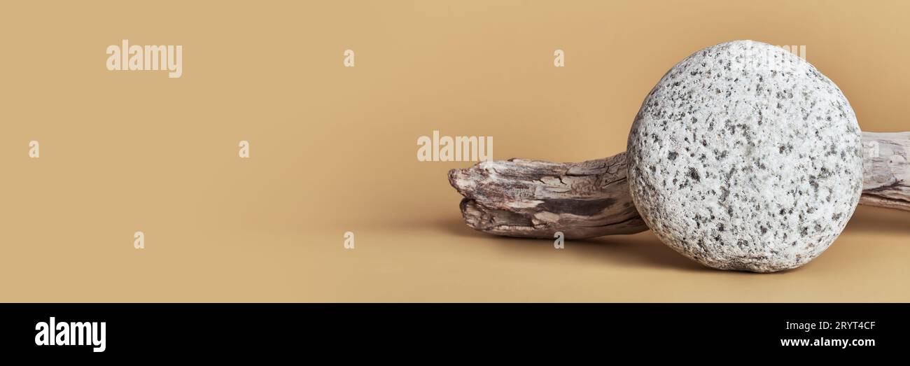 Steinkiesel und hölzernes Treibholz für die Produktpräsentation. Showcase-Konzept. Minimales naturbeiges Banner Stockfoto