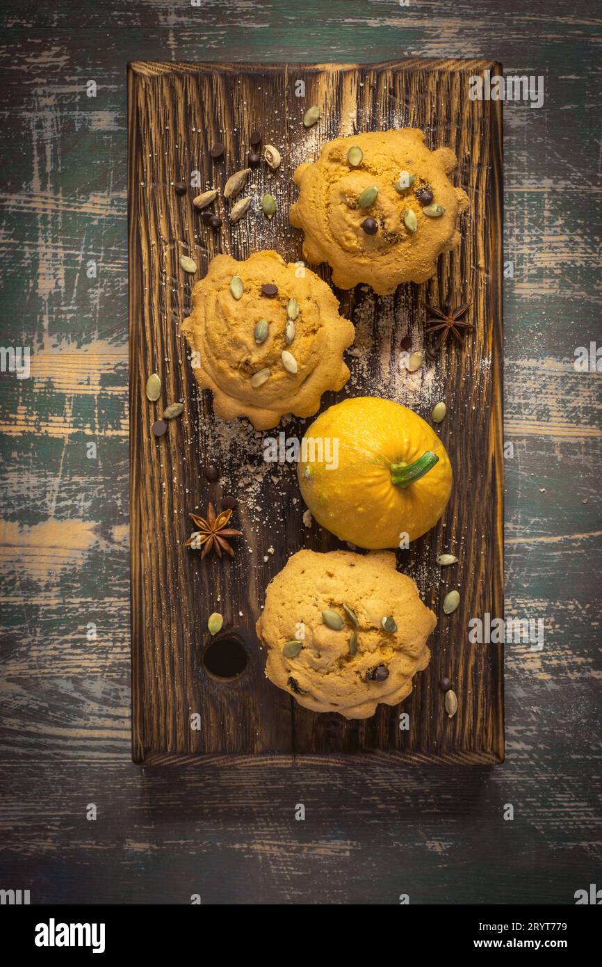 Kürbismuffins im Herbst mit Gewürzen, Schokoladentropfen und Kürbis Stockfoto