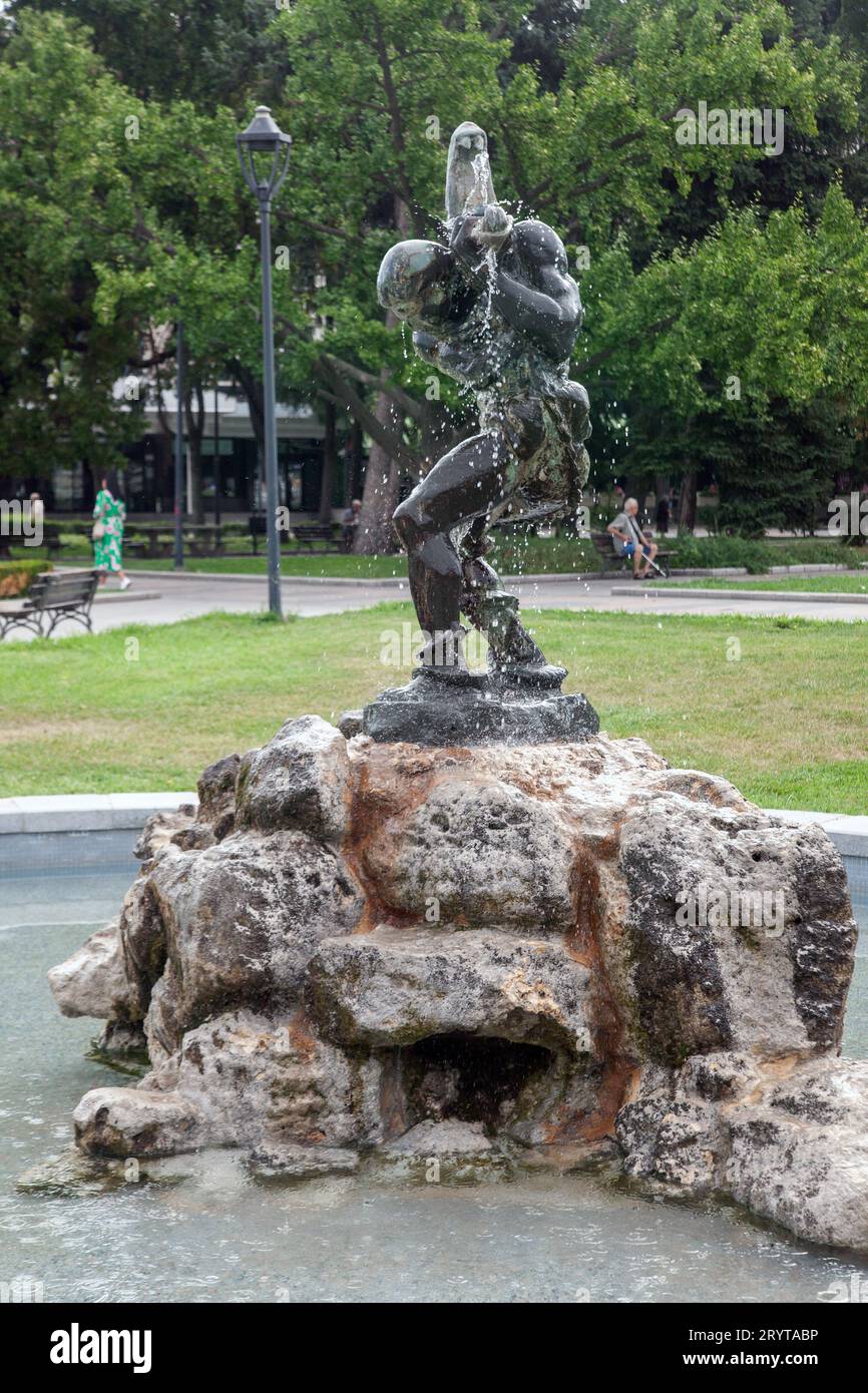 Kleiner Brunnen mit Statue auf einem Felsen im Garten von Russe, Bulgarien Stockfoto