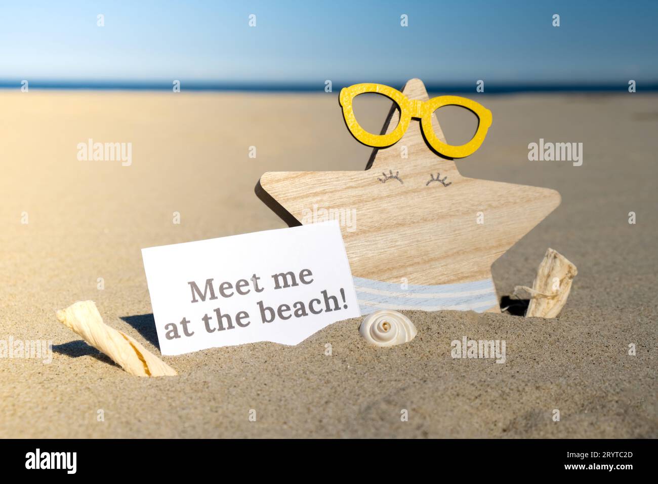 TREFFEN SIE MICH AM STRAND Text auf Papier Grußkarte auf Hintergrund von lustigen Seesternen in Gläsern Sommer Urlaub Dekor. Sandstrand s Stockfoto