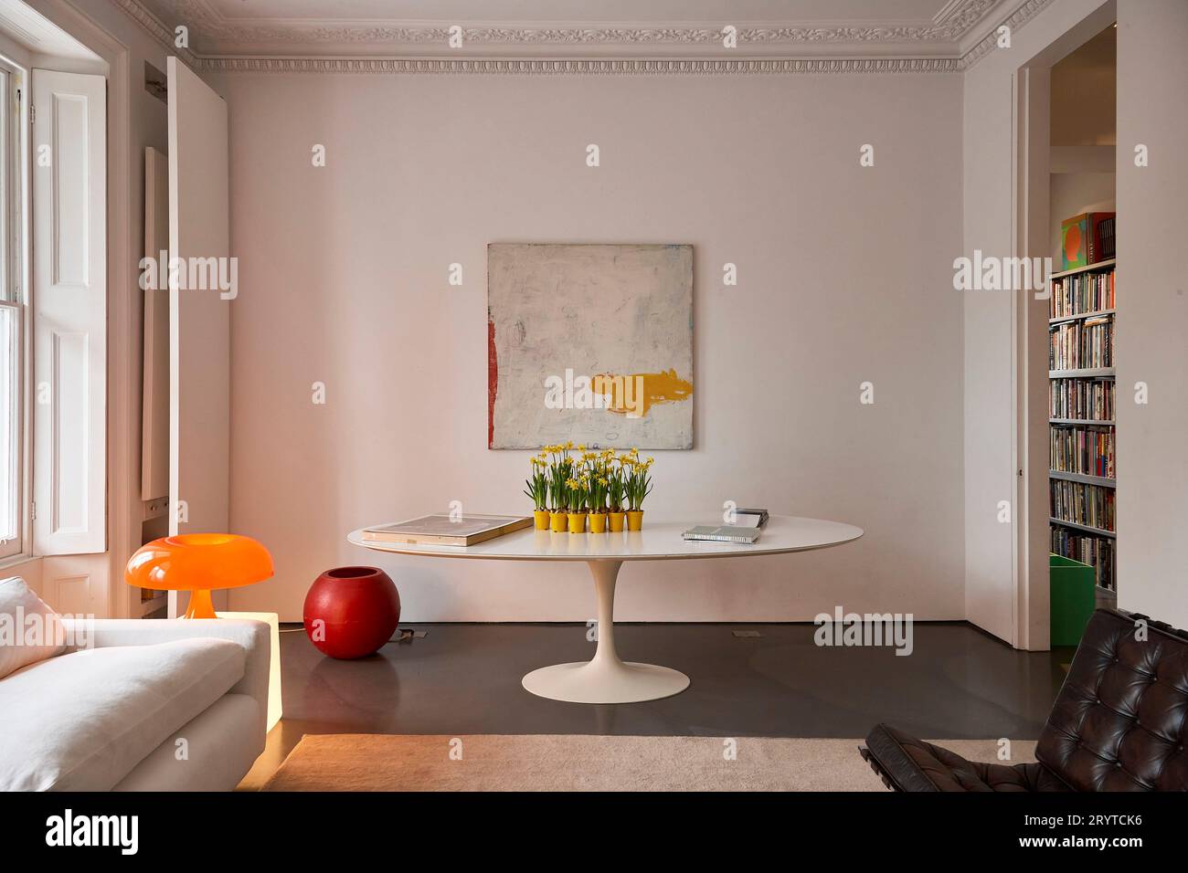 Wohnzimmer im Erdgeschoss, einfarbig weiß mit Tisch. End House, Kensington, Großbritannien. Architekt: Fiona Cowan, 2010. Stockfoto