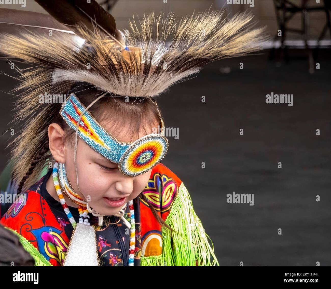 Calgary, Alberta, Kanada. Juni 2023. Eine mittelgroße Aufnahme eines Talents eines indigenen Kindes, das ein gelbes traditionelles Tuch trägt Stockfoto