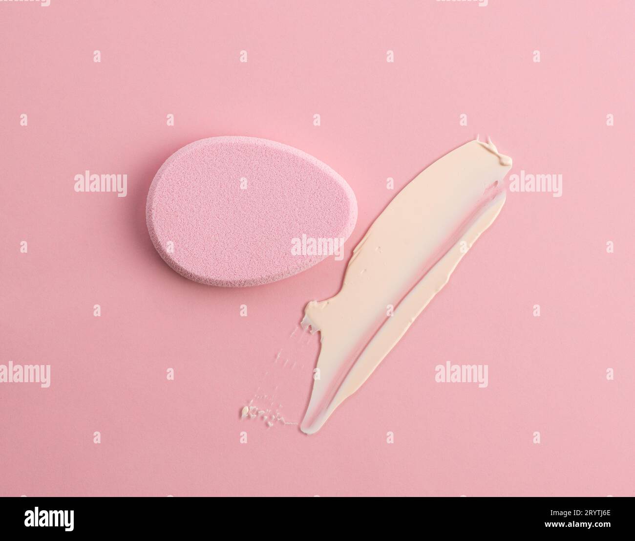 Kosmetikschwamm in Form eines Eies auf pinkfarbenem Hintergrund. Draufsicht Stockfoto