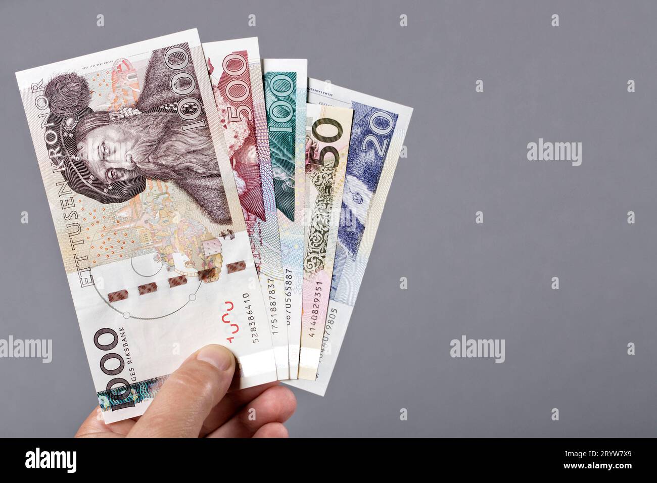 Alte schwedische Krone in der Hand auf grauem Hintergrund Stockfoto