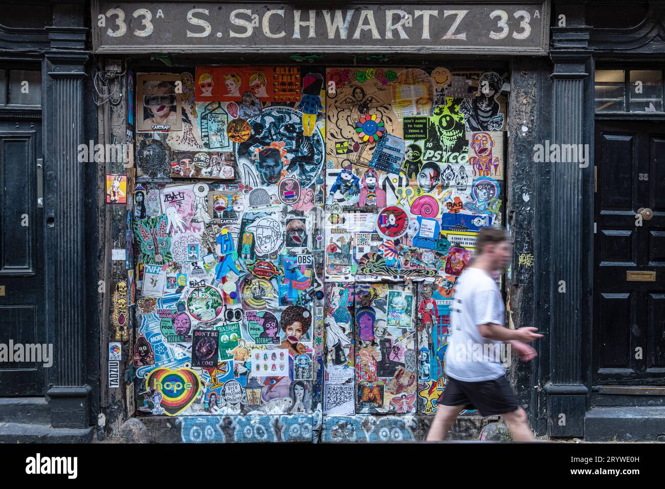 Ein Mann geht am Eingang von S Schwartz in Fournier St E1 vorbei. Stockfoto