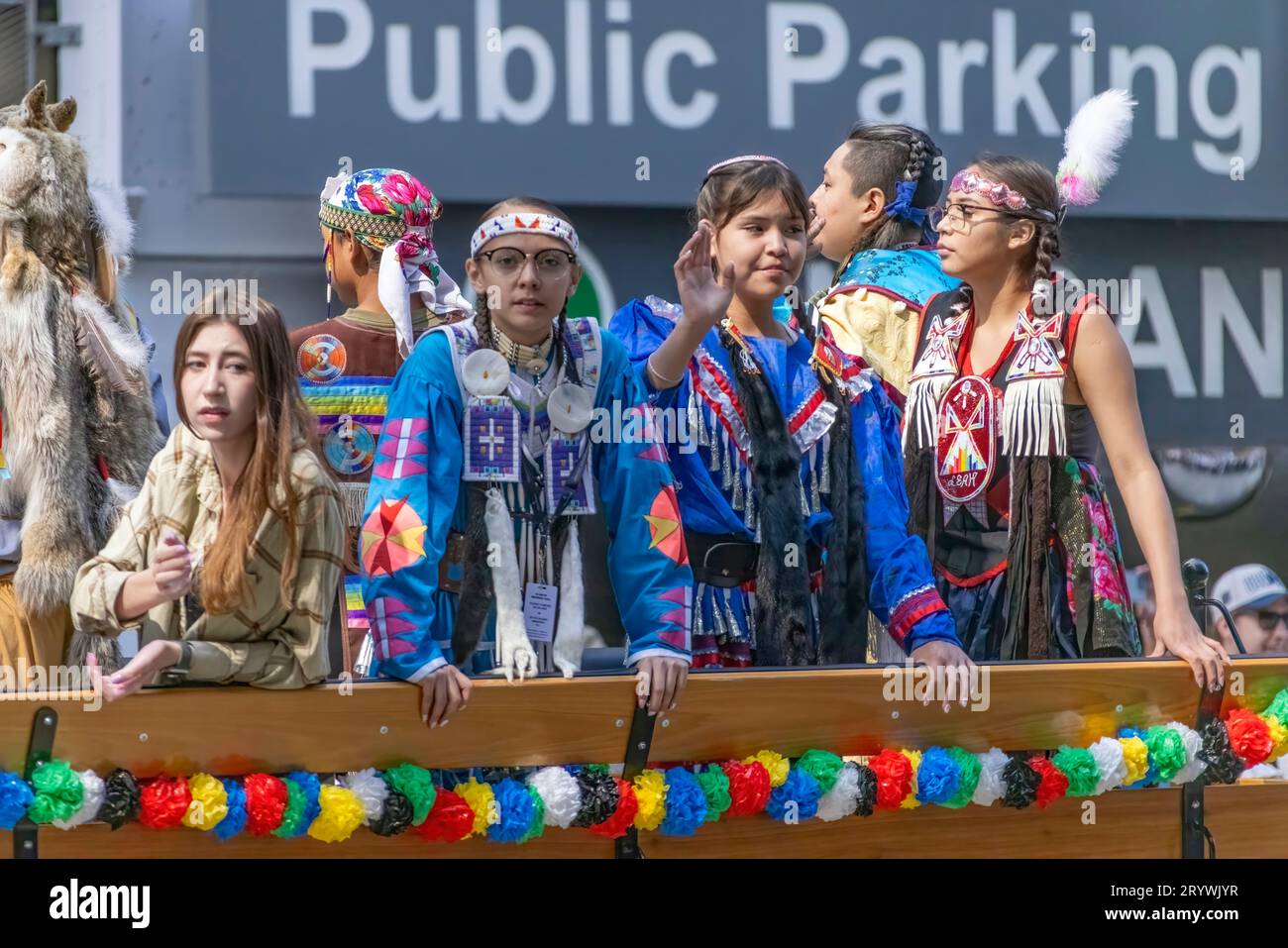 Calgary, Alberta, Kanada. Juli 2023. Ein junger Teenager der First Nations, der traditionelle Tücher trägt, während er auf einem Auto fährt Stockfoto