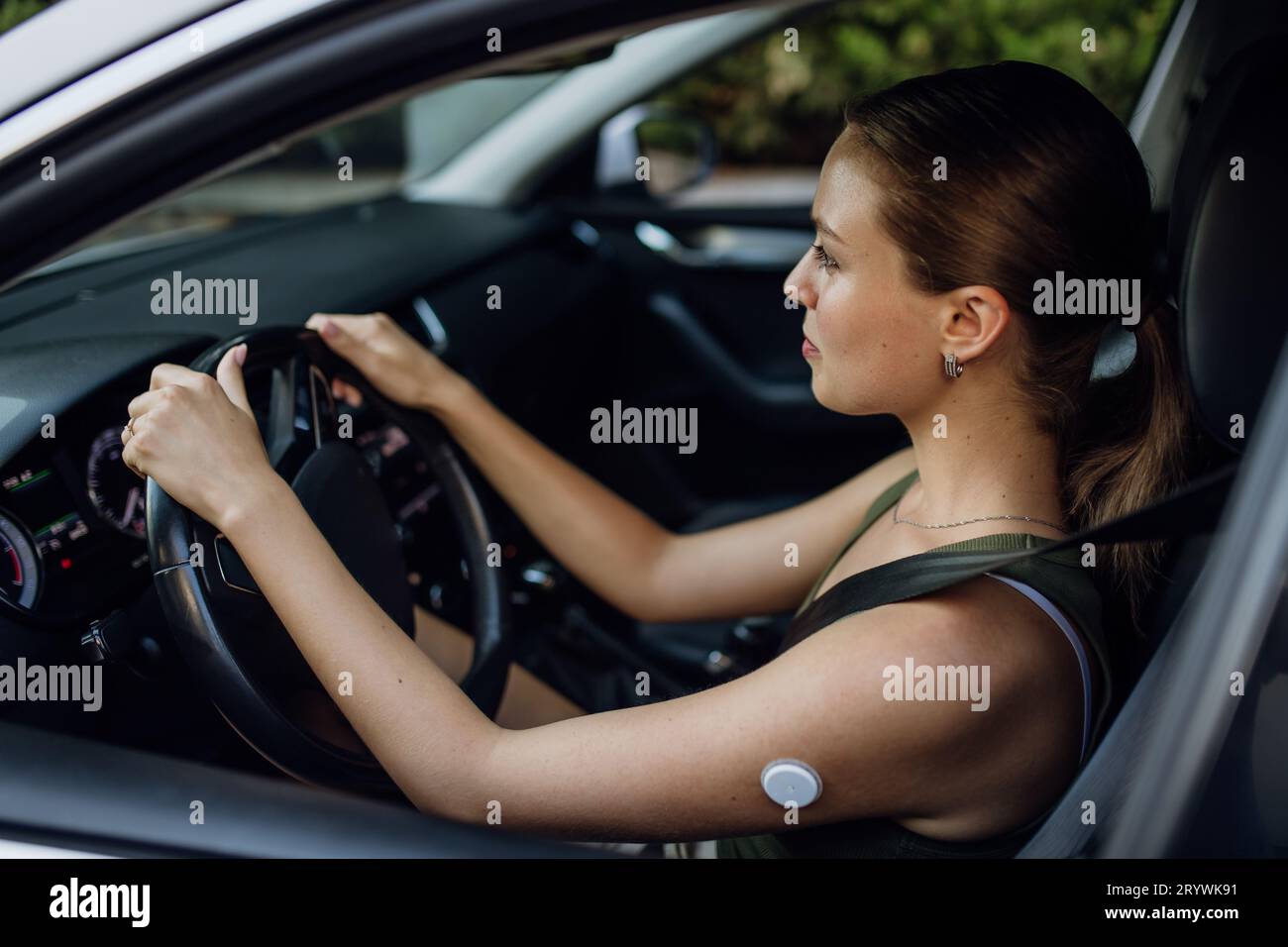 Frau mit Diabetes, die ihren Blutzucker während der Autofahrt überwacht. Stockfoto