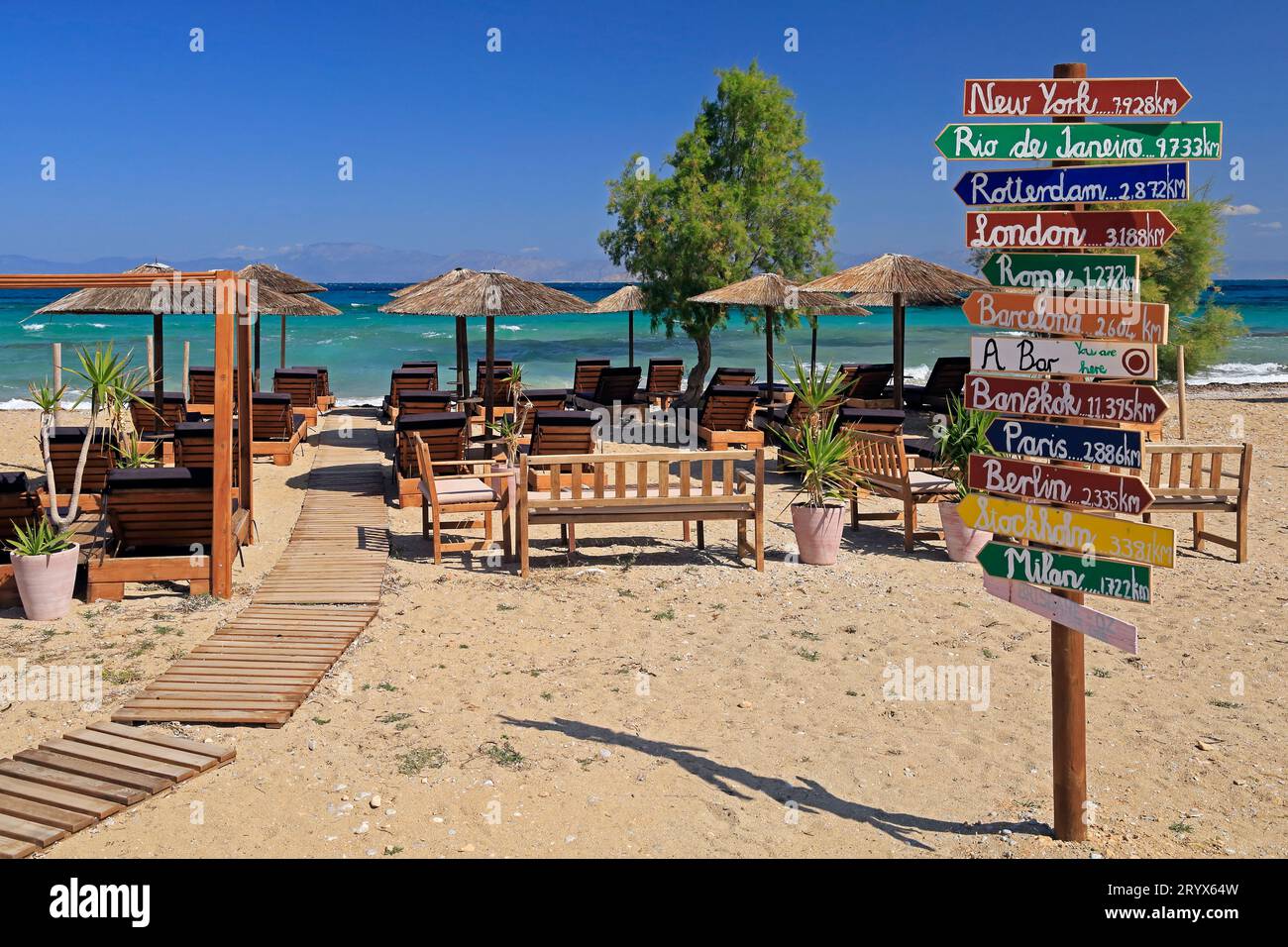 Wegweiser zu exotischen Reisezielen in einer Strandbar, Agibri Insel, Saronischer Golf, Griechenland. Mai 2023. Stockfoto
