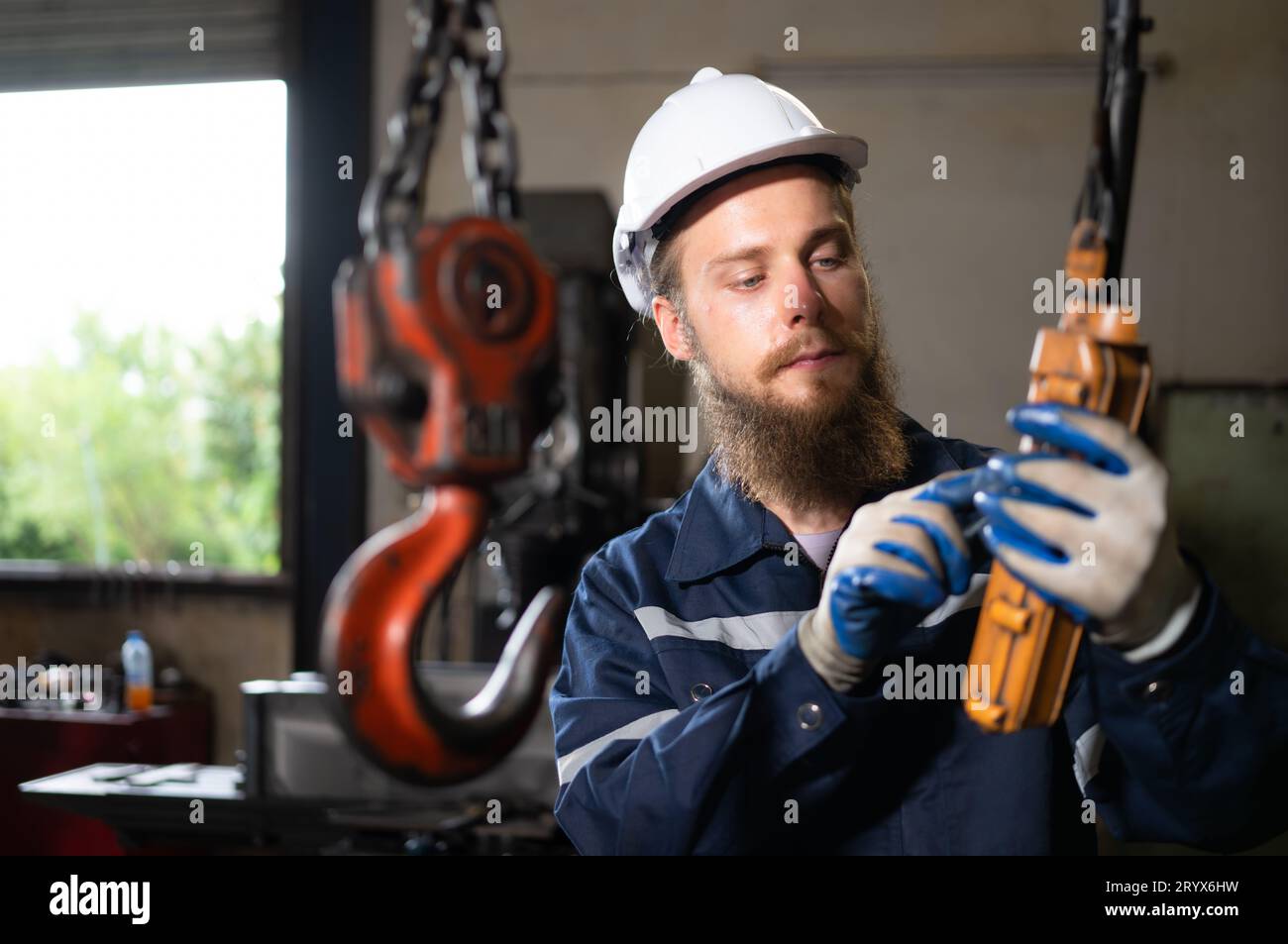 Techniker, die den Betrieb von Hebekranen in schweren Industrieanlagen überprüfen und testen. Stockfoto