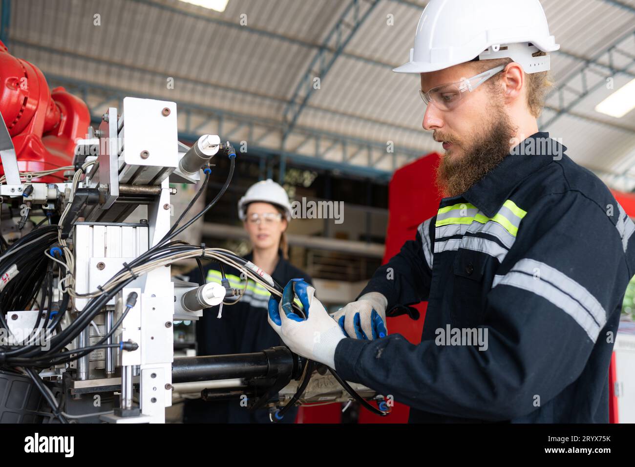 Elektroingenieur mit der Mission, ein elektrisches System für den Roboterarm zu installieren Stockfoto