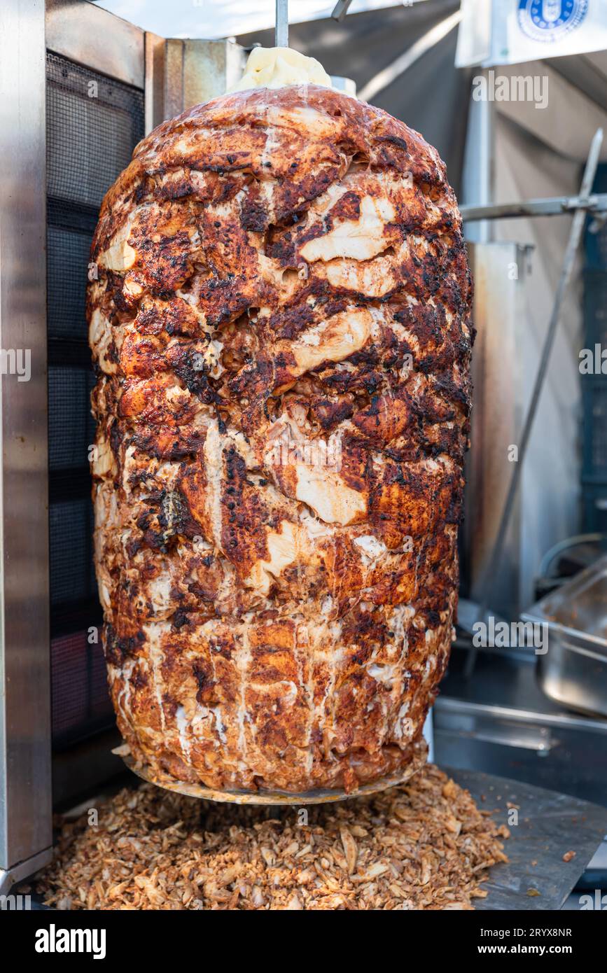 Gegrilltes Hühnchenfleisch auf einer vertikalen Rotisserie verwendet in traditionellem türkischen Street Food Döner Kebab, verbranntes ungesundes Fleisch Konzept. Hochwertige Fotos Stockfoto