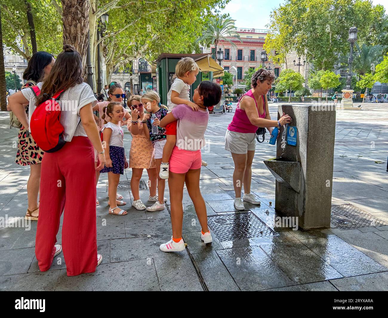 Sevilla, Spanien, große Menschenmenge, Familie mit Kindern, Trinkwasser am heißen Tag, Hitzewelle auf der Straße, im Altstadt-Zentrum, Stockfoto