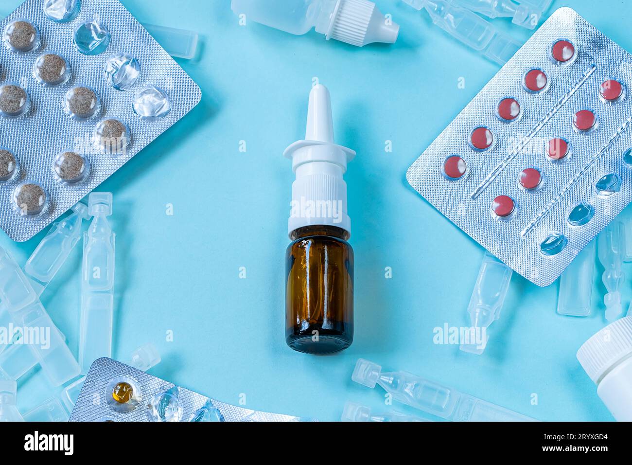 Erkältungszeit und Krankheitszeit. Medikamente und Pillen auf blauem Hintergrund. Nasenspray für laufende Nase und Gewebe. Stockfoto