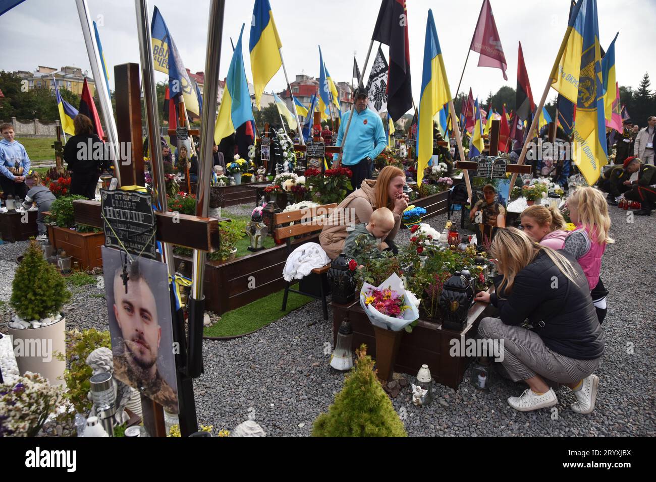 Lviv, Ukraine. Oktober 2023. Verwandte sitzen in der Nähe des Grabes eines ukrainischen Soldaten, der während des russisch-ukrainischen Krieges getötet wurde, auf dem Lychakiv-Friedhof in Lemberg am Tag des Verteidigers der Ukraine. (Foto: Pavlo Palamarchuk/SOPA Images/SIPA USA) Credit: SIPA USA/Alamy Live News Stockfoto