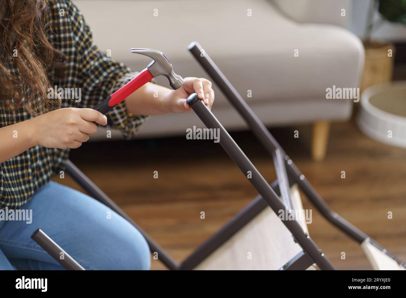 Asiatische Frau repariert Möbel-Renovierung selbst, indem sie Ausrüstung zum selbermachen von Möbeln verwendet, die zu Hause auf dem Boden sitzen Stockfoto