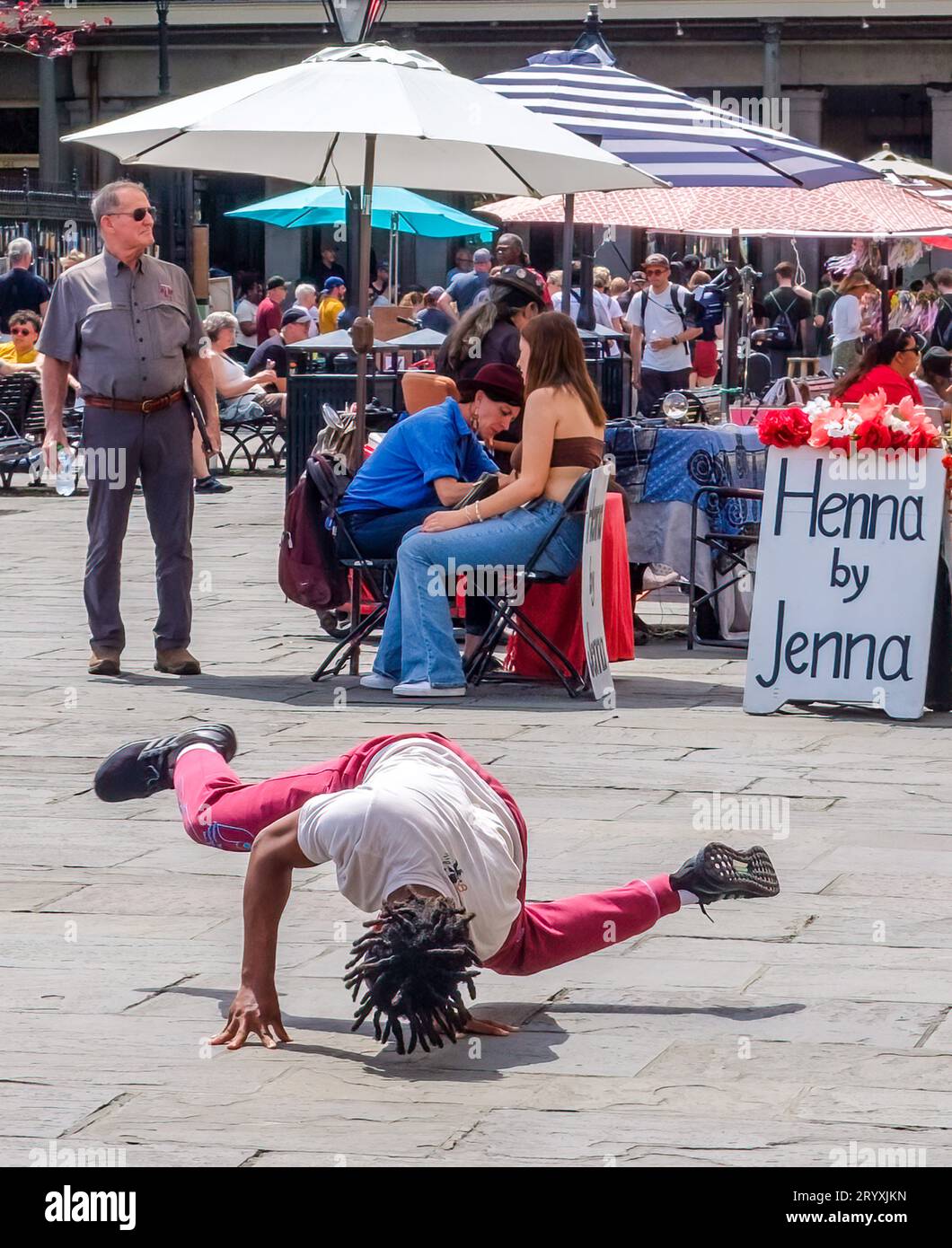 NEW ORLEANS, LA, USA - 26. MÄRZ 2023: Breakdancer dreht sich im Vordergrund mit einem Hintergrund von Touristen und Verkäufern auf dem Jackson Square Stockfoto
