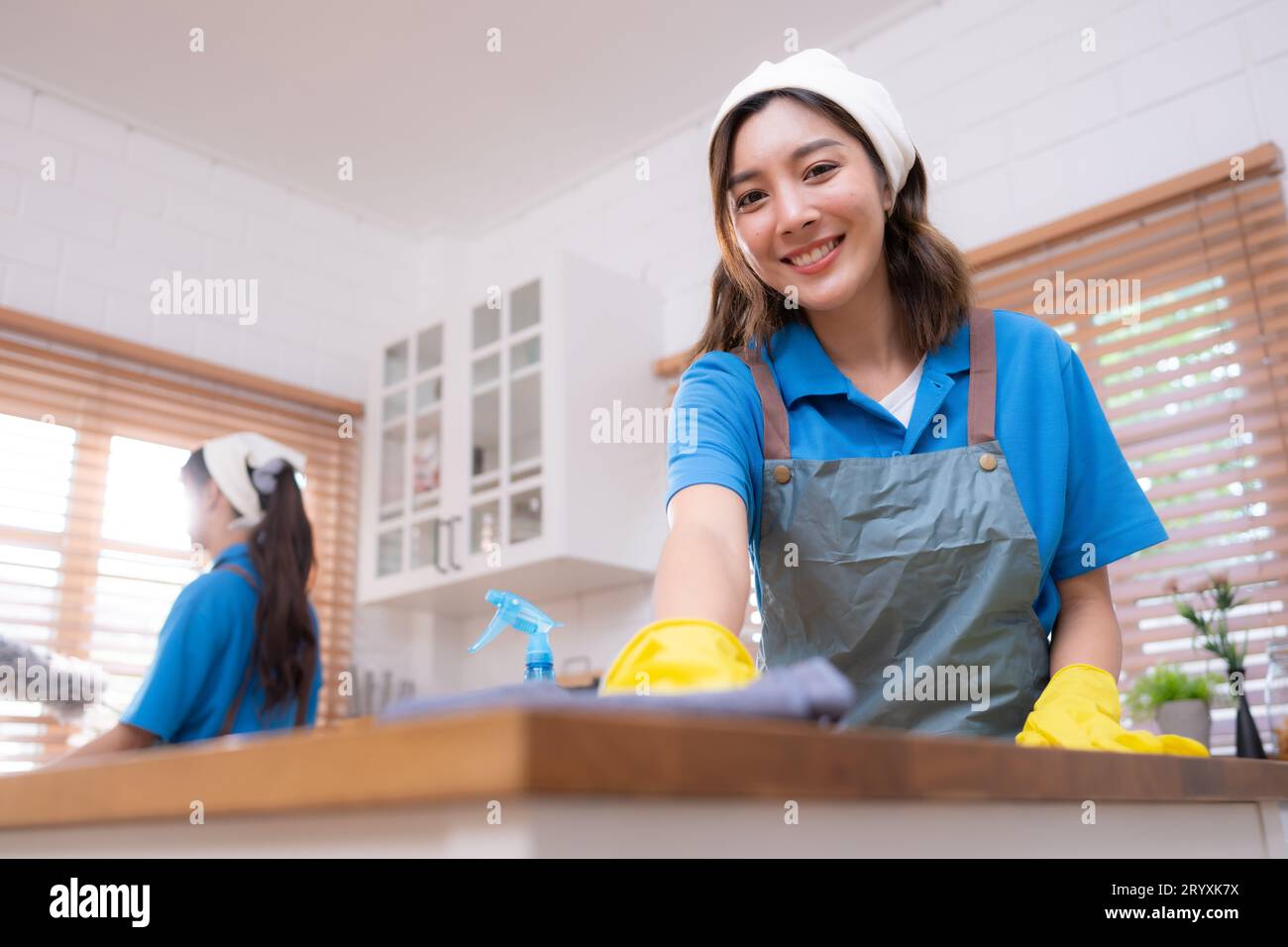 Porträt einer jungen asiatischen Frau, die zu Hause den Tisch in der Küche putzt Stockfoto