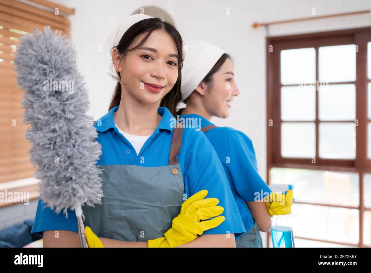 Porträt asiatischer Putzfrauen in Uniform- und Gummihandschuhen, Hausarbeitskonzept Stockfoto