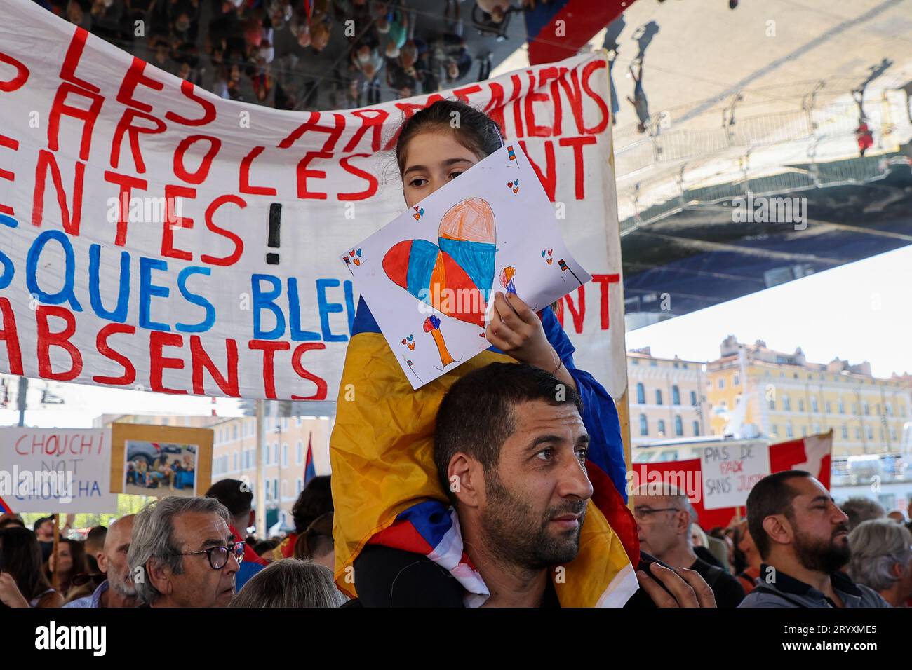 Marseille, Frankreich. Oktober 2023. Ein kleines Mädchen auf den Schultern ihres Vaters hält ein Herz in den Farben Armeniens während der Demonstration, um Aserbaidschans Militäroperation gegen die Armenier von Berg-Karabach anzuprangern. Tausende Menschen versammelten sich im Alten Hafen von Marseille, um gegen den Exodus von Armeniern aus Berg-Karabach durch die aserbaidschanische Armee zu protestieren. Die Demonstranten verurteilen die „ethnische Säuberung“ und das Schweigen der europäischen staaten. (Foto: Denis Thaust/SOPA Images/SIPA USA) Credit: SIPA USA/Alamy Live News Stockfoto