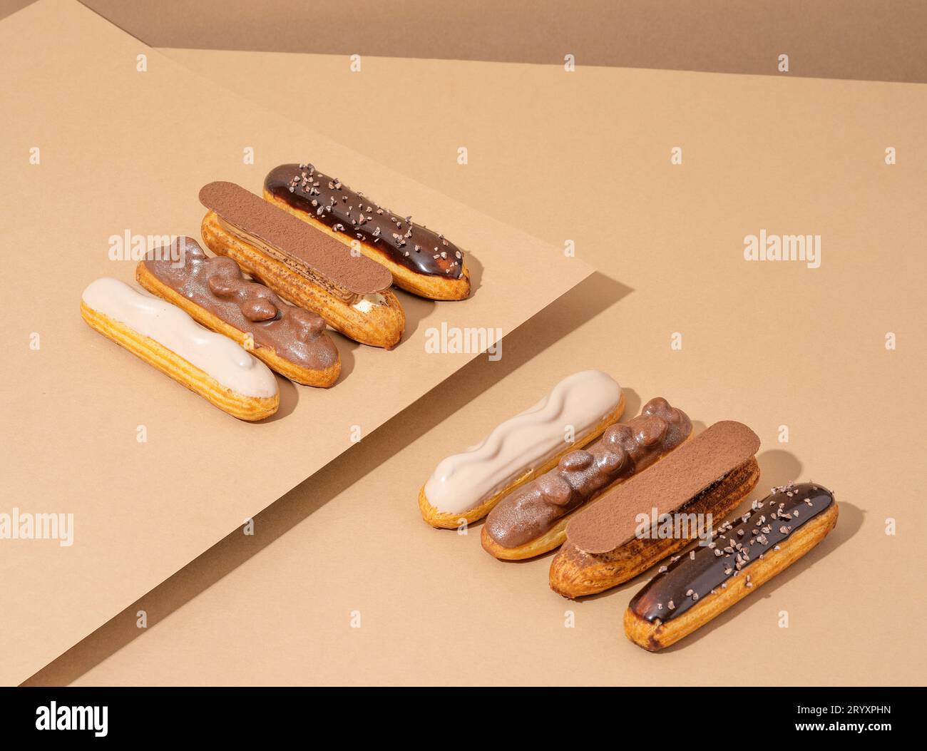 Ein Set köstlicher glasierter Donuts in verschiedenen Geschmacksrichtungen, auf einem Papppapier in einer einladenden Präsentation angeordnet Stockfoto