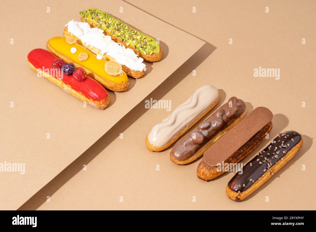 Ein Set köstlicher glasierter Donuts in verschiedenen Geschmacksrichtungen, auf einem Papppapier in einer einladenden Präsentation angeordnet Stockfoto