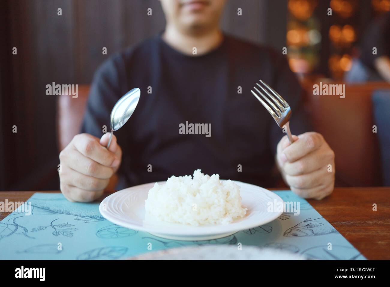 Mann isst Reis und genießt eine Mahlzeit im Restaurant. Mann beim Abendessen. Stockfoto