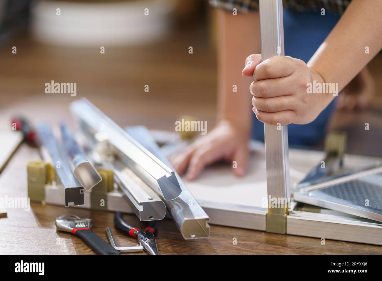 Asiatische Frau repariert Möbel-Renovierung selbst, indem sie Ausrüstung zum selbermachen von Möbeln verwendet, die zu Hause auf dem Boden sitzen Stockfoto