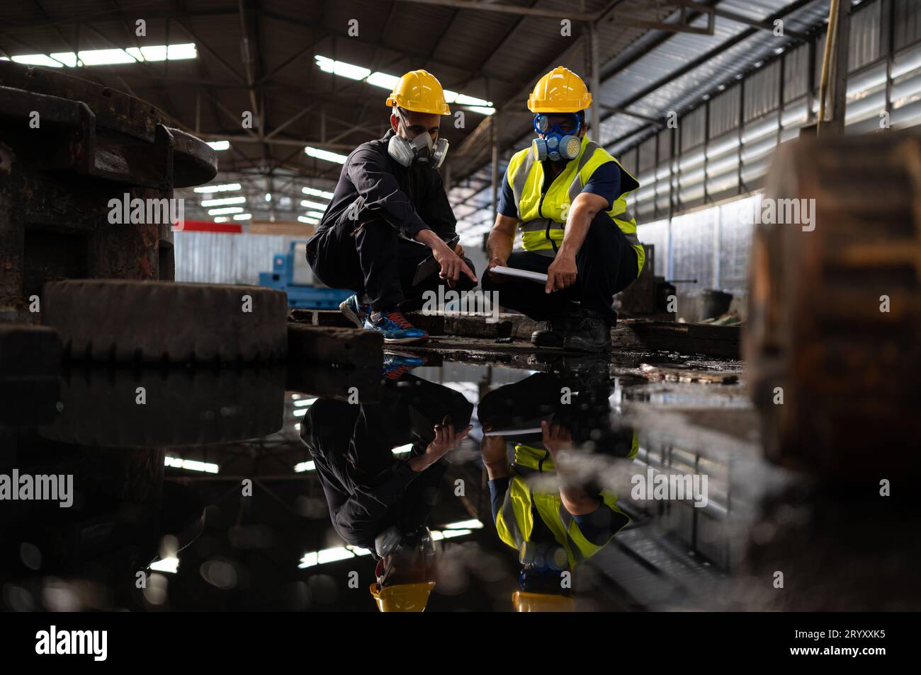 Wissenschaftler und Regierungsbeamte untersuchen und entnehmen Proben aus chemischen Leckagen in Industrieanlagen. Eingehend zu untersuchen Stockfoto