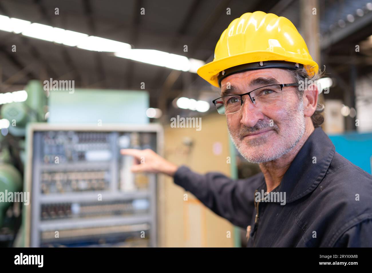 Ein leitender Ingenieur inspiziert die elektrische Anlage und repariert die mechanische Anlage im Maschinensteuerschrank. In der Reihenfolge für Th Stockfoto