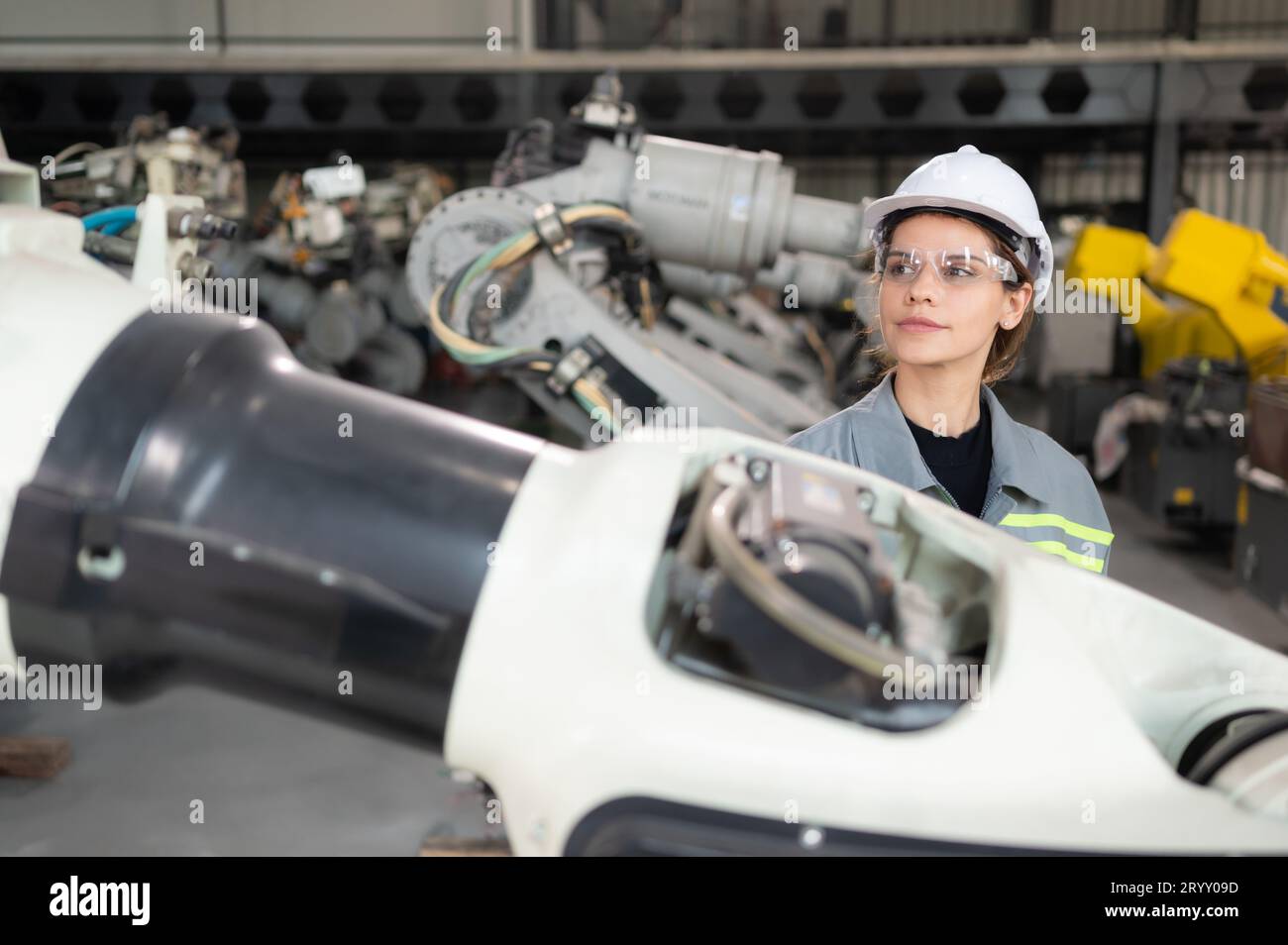 Eine Ingenieurin installiert ein Programm auf einem Roboterarm in einem Roboterlager. Und prüfen Sie die Funktion, bevor Sie die Maschine t senden Stockfoto