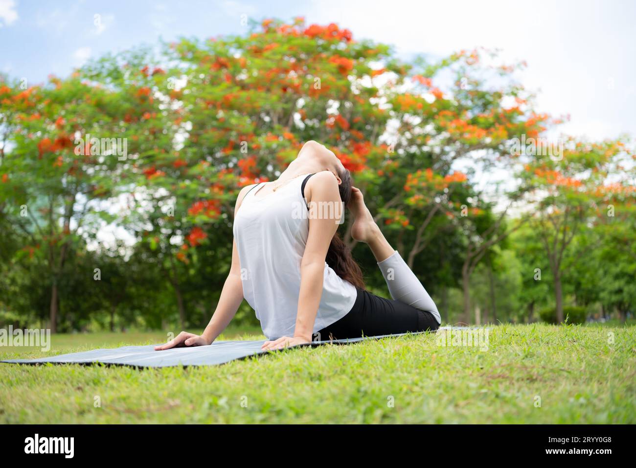 Junge Frau mit Outdoor-Aktivitäten im Stadtpark, Yoga ist ihre gewählte Aktivität. Stockfoto