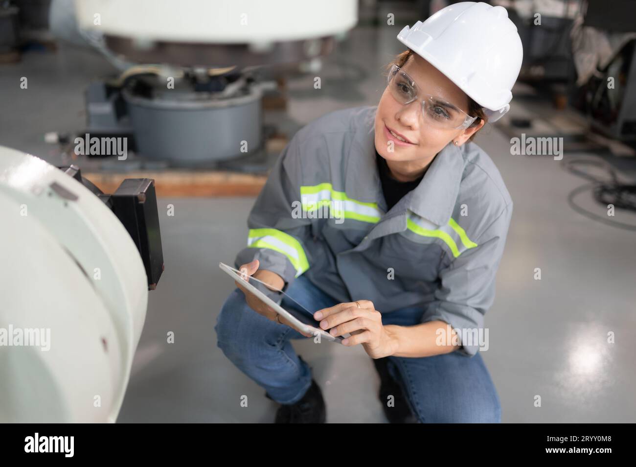 Eine Ingenieurin installiert ein Programm auf einem Roboterarm in einem Roboterlager. Und prüfen Sie die Funktion, bevor Sie die Maschine t senden Stockfoto