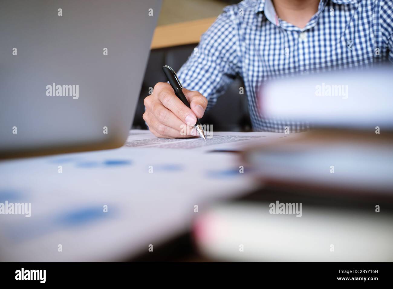 Ein Student schreibt Informationen von einem tragbaren Tablet, während er sich auf die Vorlesungen auf dem Universitätscampus vorbereitet Stockfoto