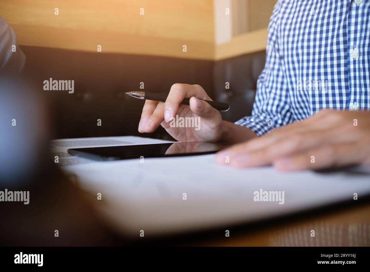 Ein Student schreibt Informationen von einem tragbaren Tablet, während er sich auf die Vorlesungen auf dem Universitätscampus vorbereitet Stockfoto