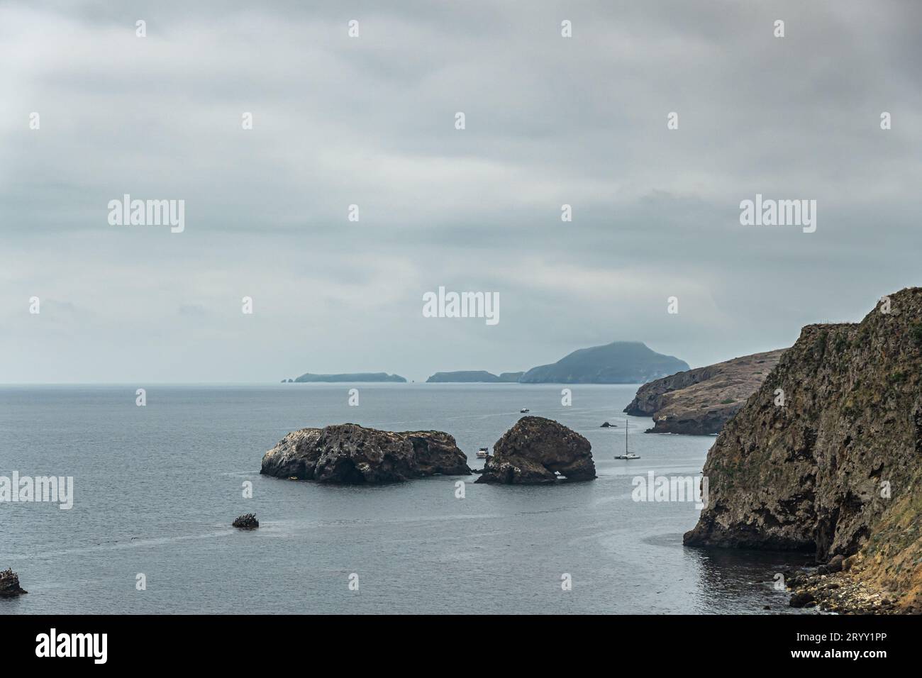 Santa Cruz Island, CA, USA - 14. September 2023: Blick auf die nordöstliche Klippenküste mit 2 kleinen Findlerinseln direkt vor der Küste und dunklen Anacapa Inseln am Horizont Stockfoto