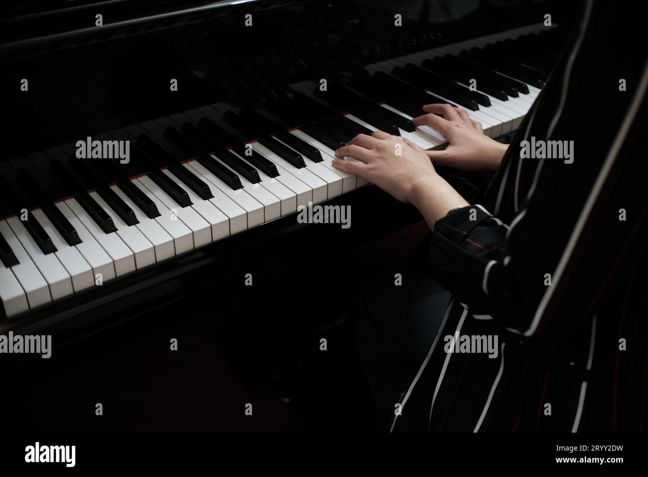 Schöne asiatische Mädchen lernen Klavier zu spielen. Stockfoto