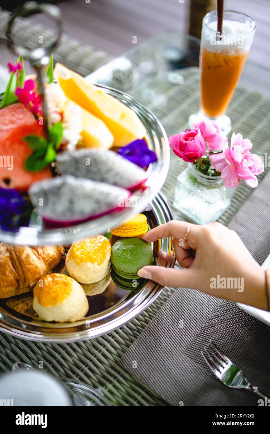 Nachmittagstee mit Mini-Brioche-Kanapees. Wunderschöne englische Nachmittagstee-Zeremonie mit Desserts und Snacks Stockfoto