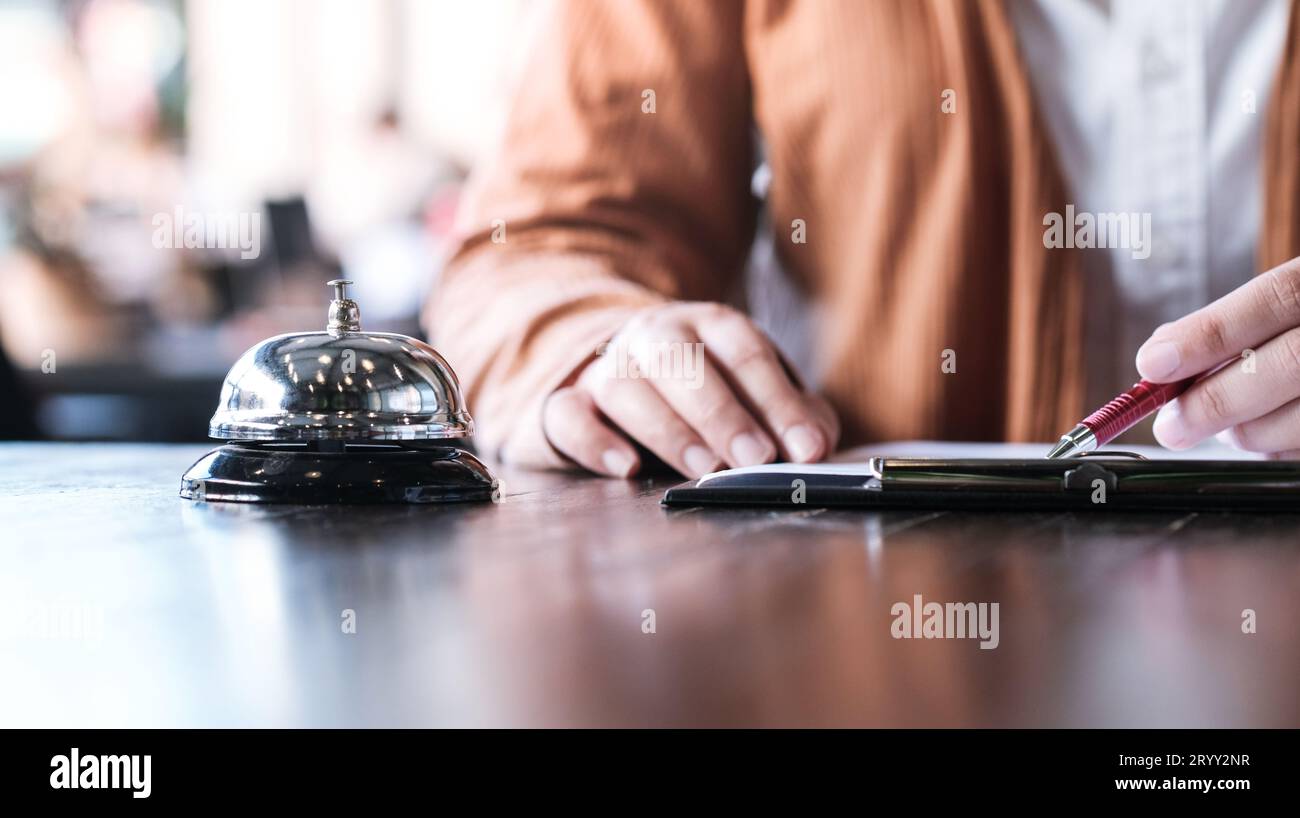 Frau Gast an der Rezeption des Hotels, die eincheckt. Stockfoto