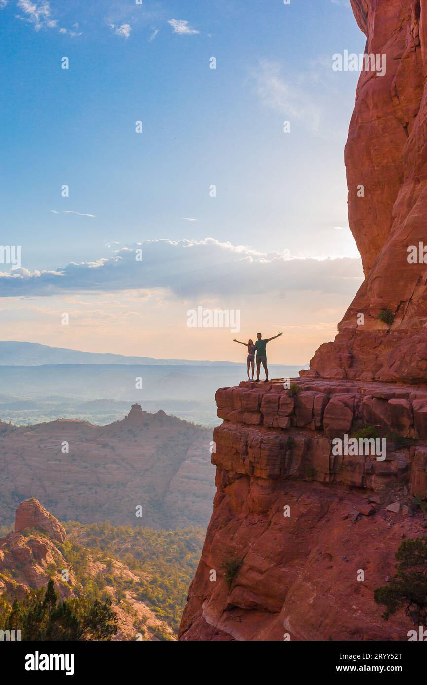 Silhouette von Vater und Tochter auf dem Weg am Cathedral Rock bei Sonnenuntergang in Sedona. Der farbenfrohe Sonnenuntergang über Sedonas Katheter Stockfoto